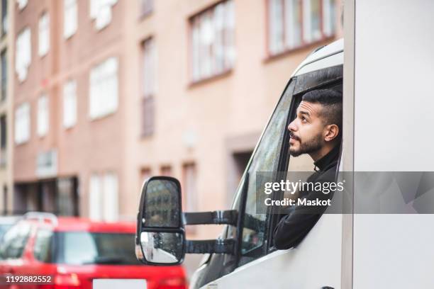 male mover looking up through truck window - part time worker stock pictures, royalty-free photos & images