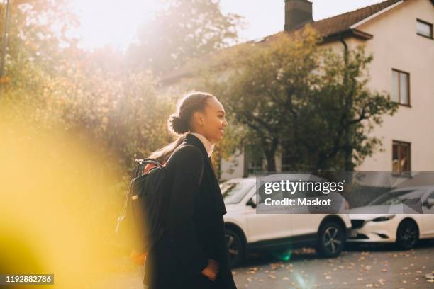 side view of teenage girls walking against cars and house during autumn - teenager alter photos et images de collection