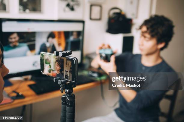 girl filming friend on mobile phone using camera while sitting at home - influencer fotografías e imágenes de stock