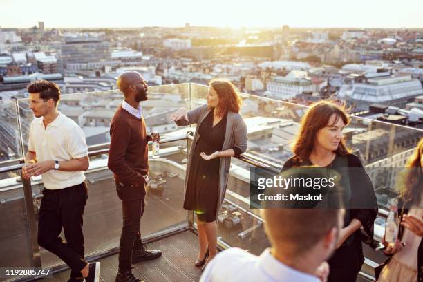 business coworkers discussing on terrace at after work party - kick off stock-fotos und bilder