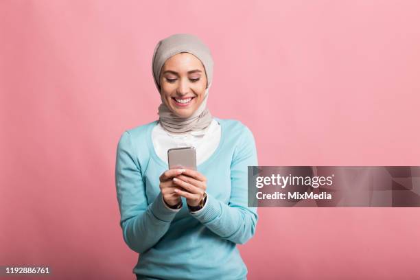 young arabian woman holding the phone - arab woman studio stock pictures, royalty-free photos & images