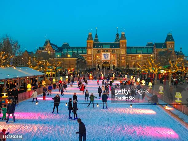 mensen schaatsen op een ijsring voor het rijksmuseum in amsterdam - museumplein stockfoto's en -beelden