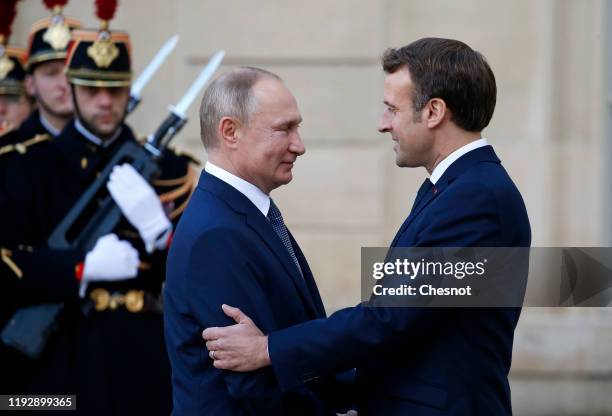 French President Emmanuel Macron welcomes Russian President, Vladimir Putin as he arrives at the Elysee Presidential Palace to attend a summit on...