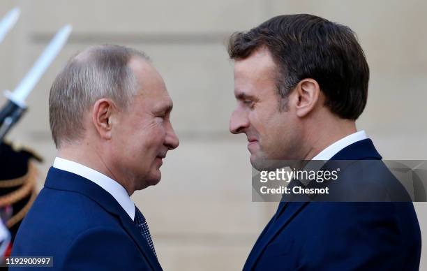 French President Emmanuel Macron welcomes Russian President, Vladimir Putin as he arrives at the Elysee Presidential Palace to attend a summit on...