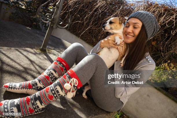 woman hugging and giving love to her dog pet during winter cozy morning at backyard home. - pet clothing foto e immagini stock