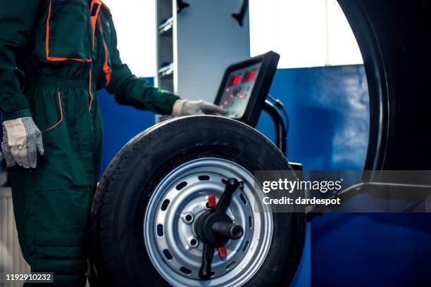 mechanic man working on balancing machine - truck repair stock pictures, royalty-free photos & images