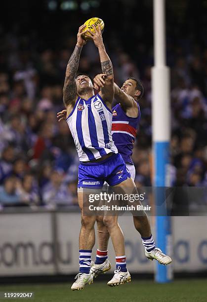 Aaron Edwards of the Kangaroos marks in front of Lindsay Gilbee of the Bulldogs during the round 17 AFL match between the North Melbourne Kangaroos...