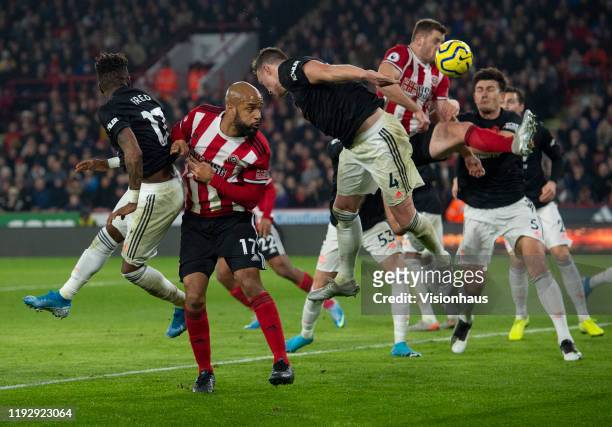 David McGoldrick of Sheffield United goes up for a header with Phil Jones and Fred of Manchester United during the Premier League match between...