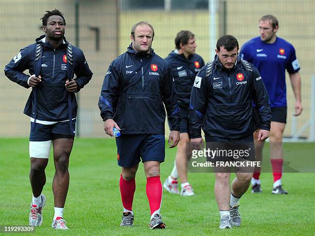 France's rugby union national team backrow Fulgence Ouedraogo, prop William Servat and Thomas Domingo leave a pitch at the end of a training session...