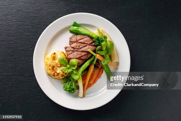 veal tenderloin with sesonal vegetables. - dinner plate stock pictures, royalty-free photos & images