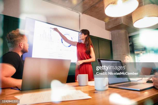 femme d'affaires confiante présente des progrès trimestriels dans la réunion utilisant un grand écran d'affichage - skill photos et images de collection