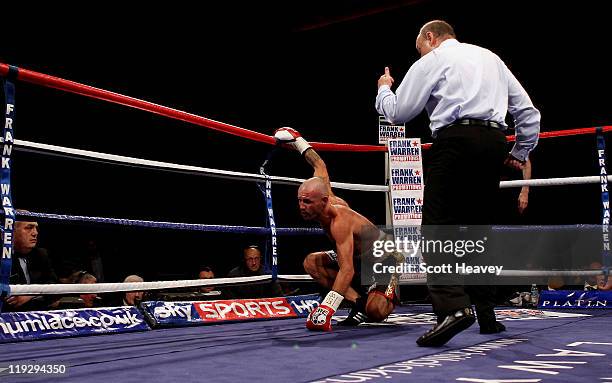 Nicky Cook is knocked down in the first round by Ricky Burns during the WBO World Super Feather-Weight Championship bout at Echo Arena on July 16,...