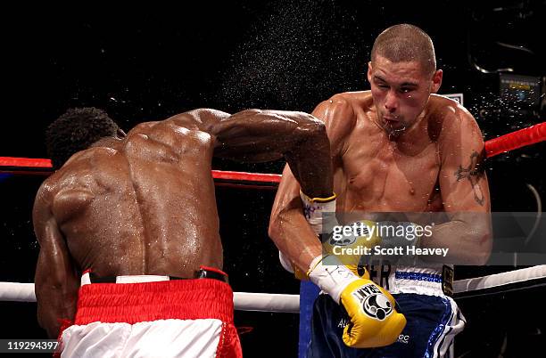 Tony Bellew is caught by Ovill McKenzie during the Commonwealth And Vacant British Light-Heavyweight Championship bout at Echo Arena on July 16, 2011...