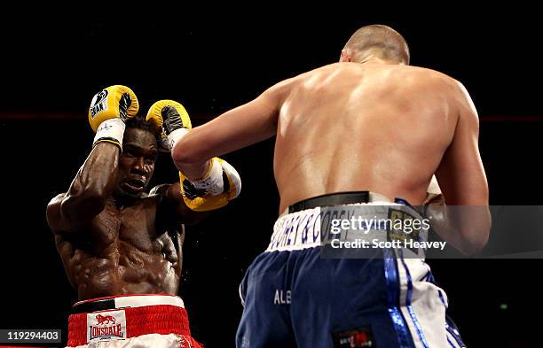 Tony Bellew battles with Ovill McKenzie during the Commonwealth And Vacant British Light-Heavyweight Championship bout at Echo Arena on July 16, 2011...