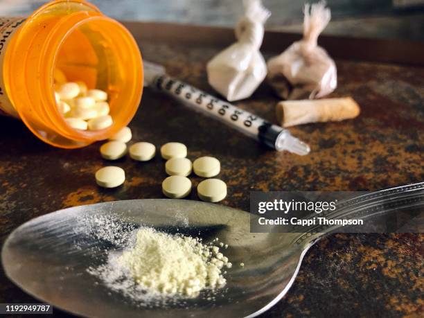 narcotic drugs with syringe and spoon - heroïne stockfoto's en -beelden