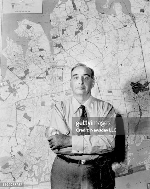 Long Island, New York: Undated 1954 file photo of planner Robert Moses standing in front of map of Long Island, New York.