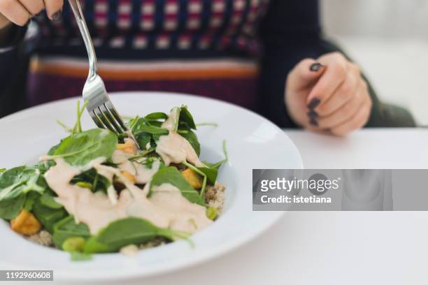pregnant woman eating fresh vegan salad at cafe - dressing up stock-fotos und bilder