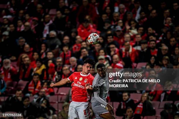 Benfica's Spanish midfielder Gabriel Appelt heads the ball with Aves' French forward Kevin Yamga during the Portuguese league football match between...