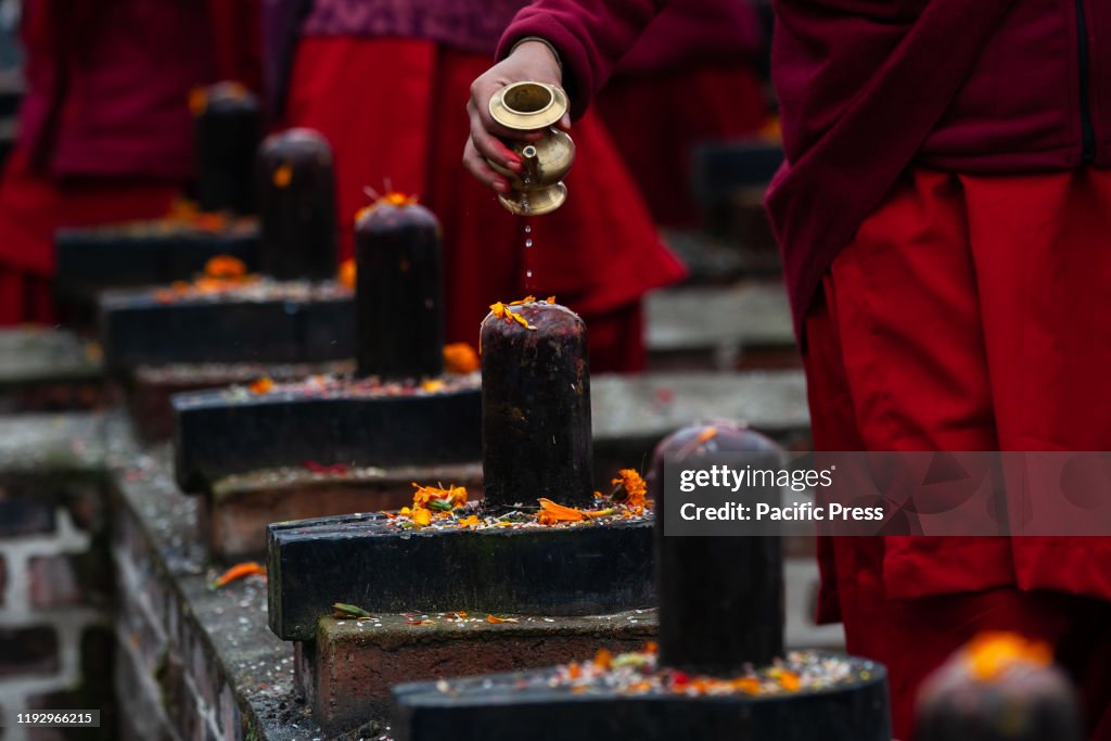 Nepali Hindu devotee  offering  holy water to a Shiva lingam...