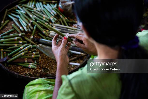 Overview of a woman making traditional, cheroot cigars at a local production facility in the Inle lake area.