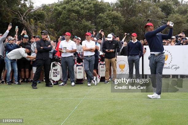 Playing Captain Tiger Woods of the United States team plays a shot as Patrick Cantlay, Justin Thomas and Patrick Reed look on ahead of the 2019...