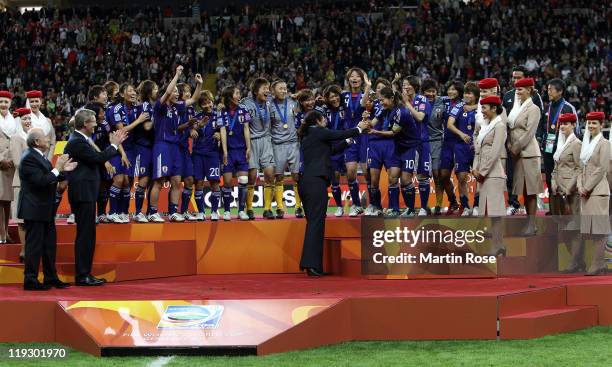 President Steffi Jones hands over the trophy to Homara Sawa of Japan after the FIFA Women's World Cup Final match between Japan and USA at the FIFA...