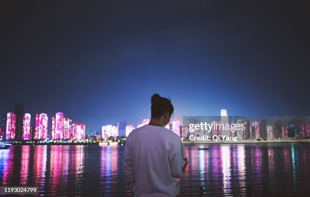 rearview of a young man against city background - wuhan 個照片及圖片檔
