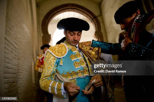 Bullfighter Enrique Ponce from Spain dresses up helped by his assistants before the third bullfight of the 2011 season at the Monumental bullring on...