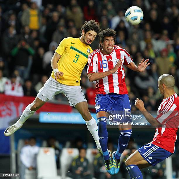 Alexandre Pato of Brazil struggles for the ball with Victor Caceres of Paraguay during a quarter final match between Brazil and Paraguay as part of...