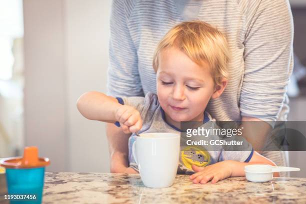 son making mommy a cup of coffee - chocolate milk stock pictures, royalty-free photos & images