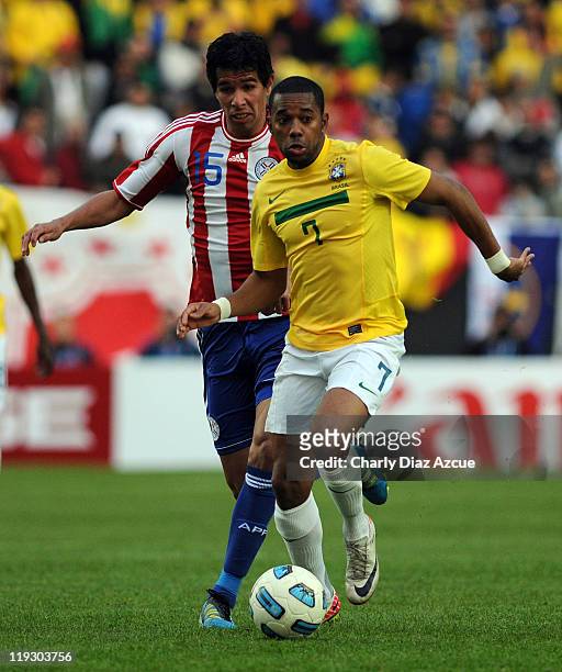 Robson De Souza of Brazil struggles for the ball with Victor Caceres of Paraguay during a match as part of the Copa America 2011 at the Ciudad de La...