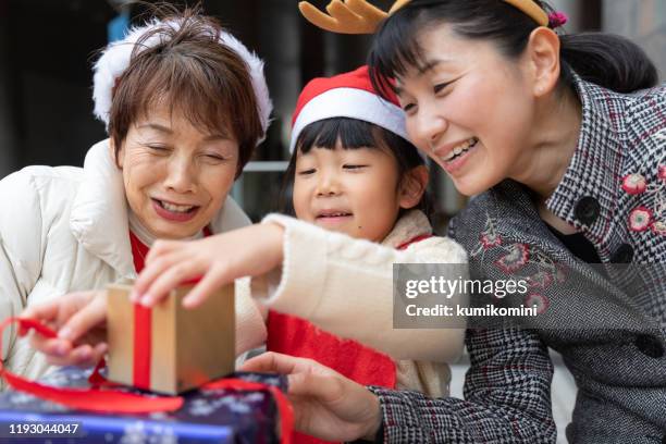 famille de plusieurs générations appréciant noel - gift japan photos et images de collection