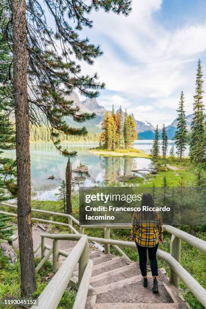 canada, alberta, jasper national park, woman admiring maligne lake and spirit island - canadian rockies stock pictures, royalty-free photos & images