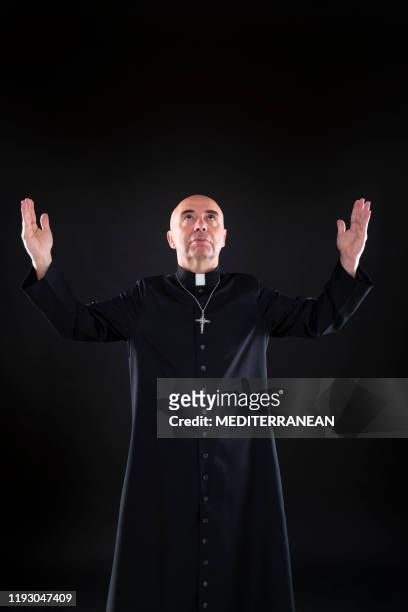 priester segenst betenden gott offene hände mit mantel - priest stock-fotos und bilder