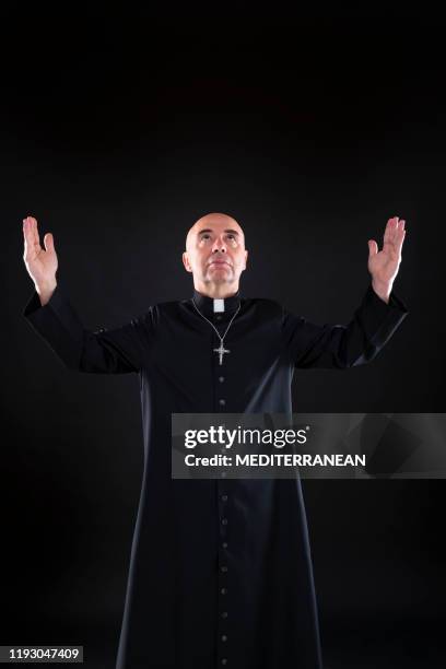 priester zegen bidden god open handen met soutane - priest stockfoto's en -beelden