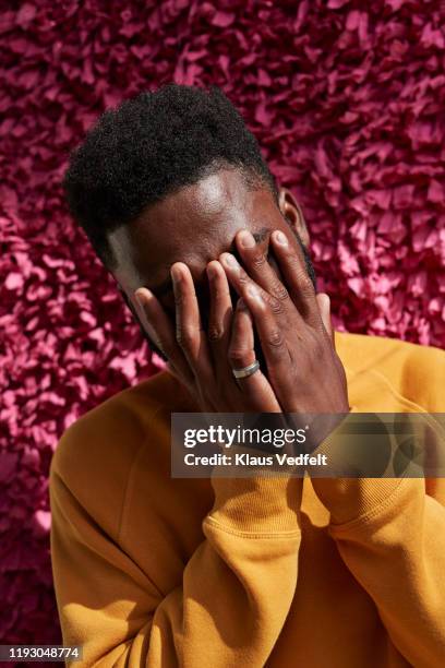 man hiding face in embarrassment against textured wall - african american man depressed bildbanksfoton och bilder