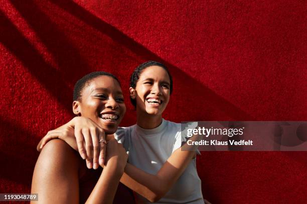 smiling young woman standing with female friend - couple laughing hugging bildbanksfoton och bilder