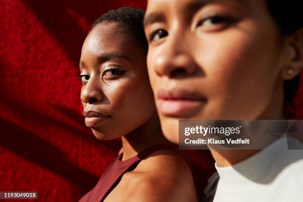 close-up of women against red wall - heroic style stockfoto's en -beelden