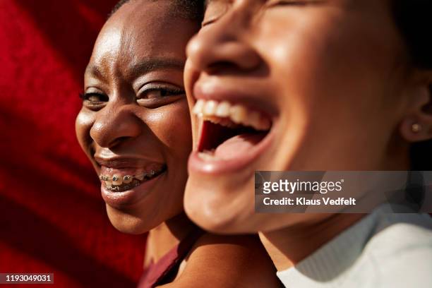 smiling multi-ethnic friends against red wall - extreme close up face stock pictures, royalty-free photos & images