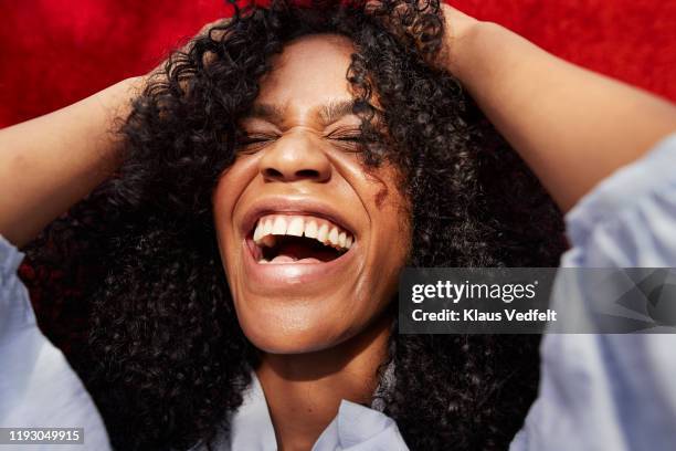 close-up of beautiful woman against red wall - sonrisa con dientes fotografías e imágenes de stock