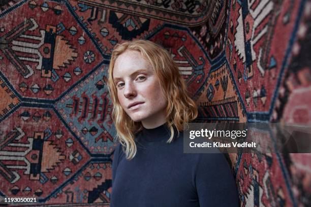portrait of woman against patterned wall - attitude stock pictures, royalty-free photos & images