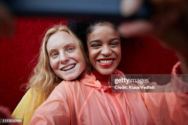 close-up of young women photographing outdoors - red clothes stock-fotos und bilder