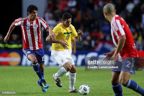 Gans of Brazil struggles for the ball with Victor Caceres of Paraguay during a quarter final match between Brazil and Paraguay as part of the Copa...