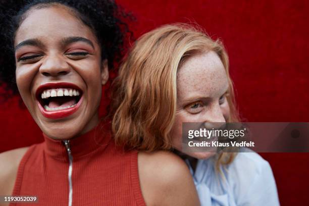 close-up of happy young females standing outdoors - lachen stock-fotos und bilder