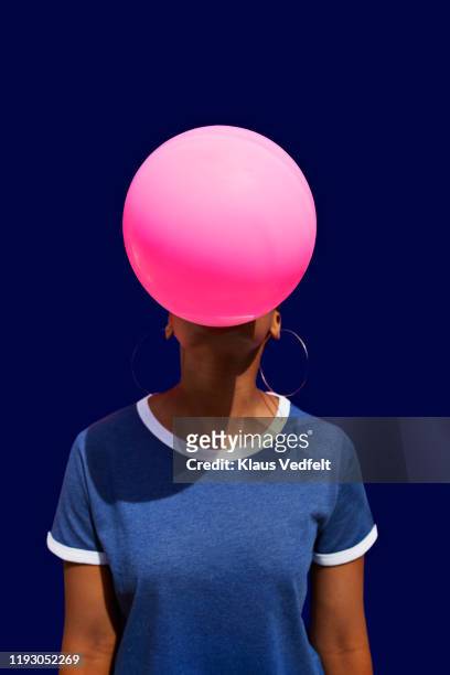 obscured face of woman blowing balloon - rosa colore foto e immagini stock