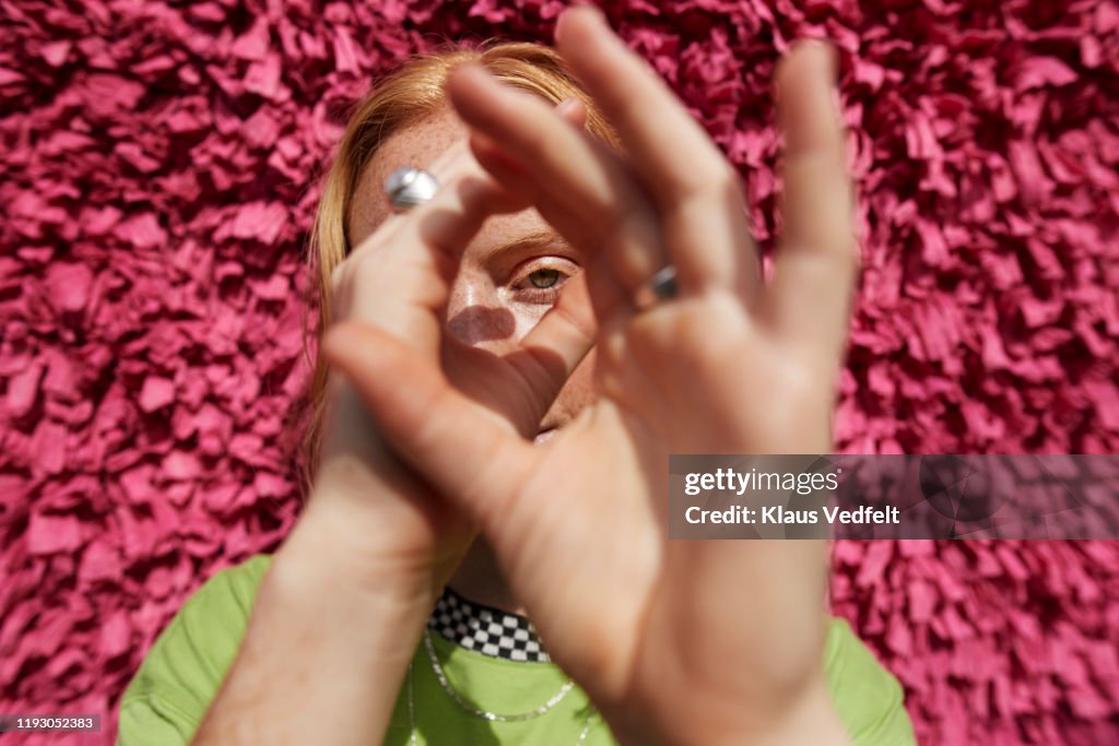 Beautiful woman gesturing against textured wall
