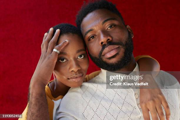 close-up portrait of friends against red wall - young black girlfriends fotografías e imágenes de stock