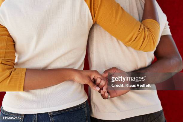 rear view of friends holding hands - hands embracing stock pictures, royalty-free photos & images