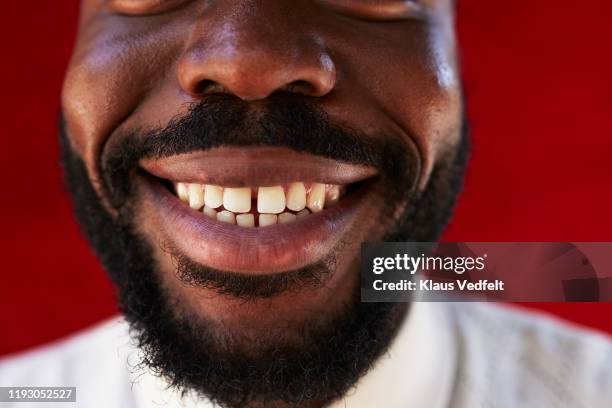 midsection of young man against red wall - sourire photos et images de collection