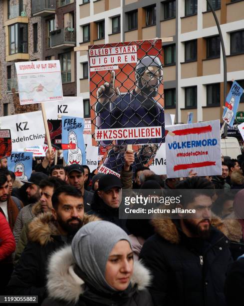January 2020, Hamburg: People demonstrate against the oppression of the Uighur Muslim minority in China. On one of the posters, the image of a Muslim...